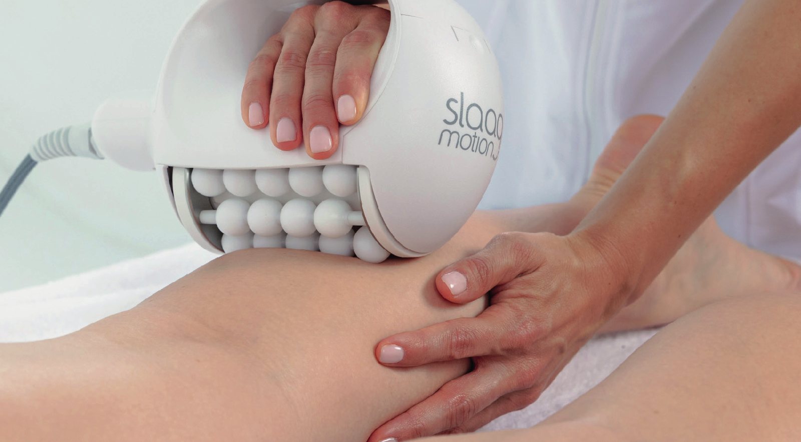 Soin Biosphère en institut Bodyminute : la pièce à main à 45 sphères rotatives appliquée sur la jambe d’une cliente